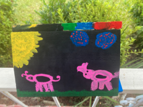Beneficiary's painting on black background with colorful animals and landscape drawings