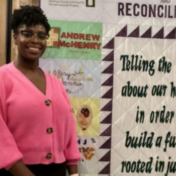 Actors and UF alumnae Anedra Small (left) and Reginald Wilson stand in front of a quilt made by members of the Alachua County Community Remembrance Project. “I can’t believe our ancestors were right below our feet,” Small said during the community dialogue. (WUFT News/ Avery Lotz)