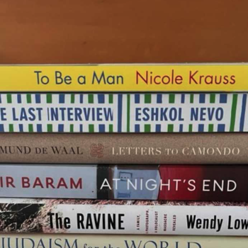 Photo of books stacked on their side. Caption reads, "The books shortlisted for the 2022 Wingate Literary Prize (Photo: Wingate Literary Prize / Twitter)"