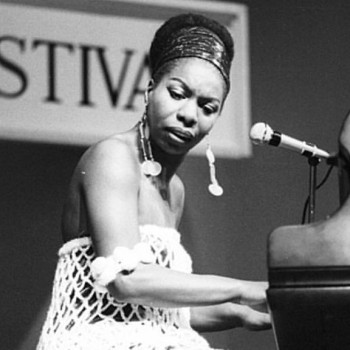 Nina Simone seated at the piano as she performs