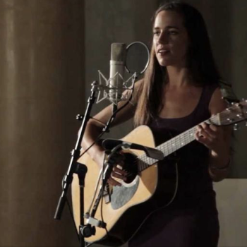 Singer songwriter Jean Rohe performing on stage with her acoustic guitar