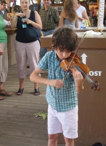 A young boy plays the violin